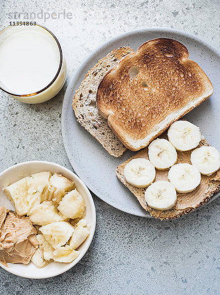 Draufsicht auf Toast mit Erdnussbutter  Banane und Milch