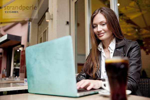 Geschäftsfrau im Bürgersteig-Café beim Tippen am Laptop  Freiburg  Deutschland