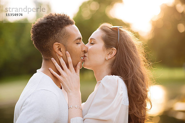 Seitenansicht eines jungen Paares  das sich küsst