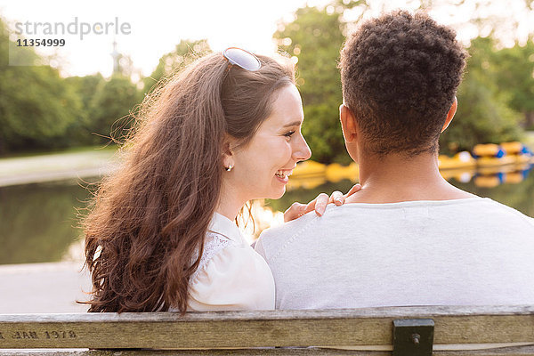 Rückansicht eines jungen Paares auf einer Parkbank