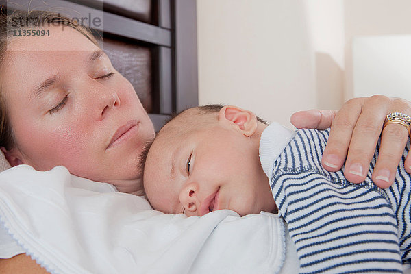 Säugling schläft auf der Brust der Mutter