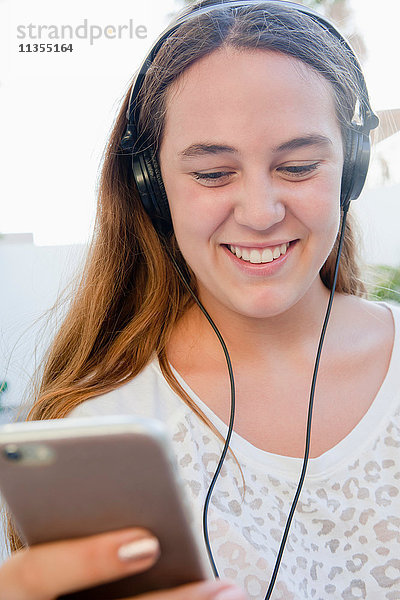 Teenager-Mädchen mit Kopfhörern lächelt