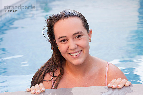 Teenager-Mädchen im Schwimmbad schaut lächelnd in die Kamera