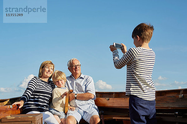 Junge fotografiert Großeltern und Bruder auf Boot