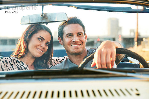 Blick durch die Windschutzscheibe eines lächelnden Paares in einem Cabriolet  Los Angeles  Kalifornien  USA