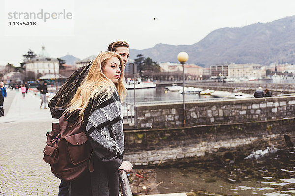 Junges Paar schaut sich am Comer See über die Schulter  Italien