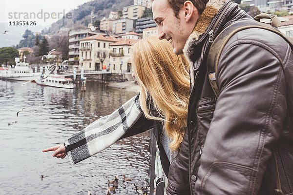 Glückliches junges Paar zeigt auf den See  Comer See  Italien