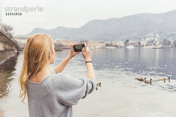 Junge Frau fotografiert vom Comer Seeufer aus  Italien