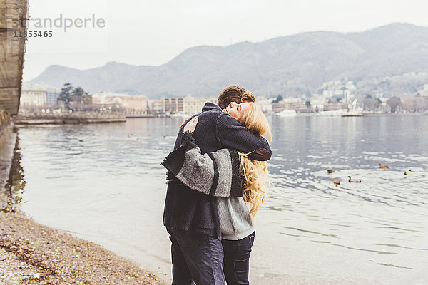 Junges Paar umarmt sich am Seeufer  Comer See  Italien