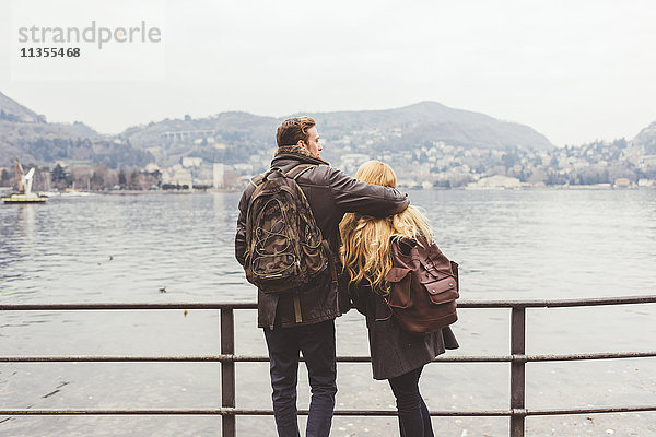 Rückansicht eines jungen Paares mit Blick auf das Seeufer  Comer See  Italien