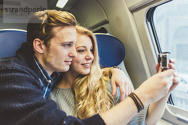 Junges Paar fotografiert durch das Fenster eines Zugwaggons  Italien