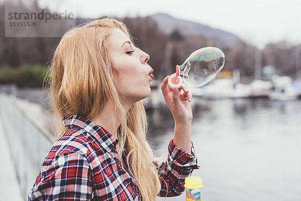 Junge Frau am Wasser beim Blasenblasen  Comer See  Italien