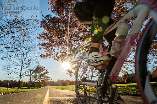 Ausschnitt eines Radfahrers  der im Sonnenlicht fährt