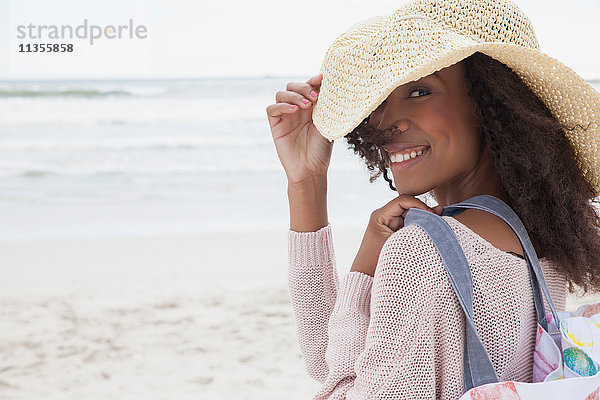 Junge Frau mit Hut am Strand