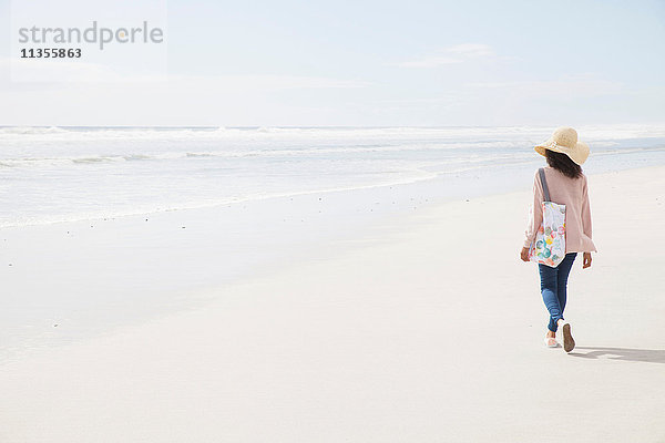 Junge Frau geht am Strand spazieren