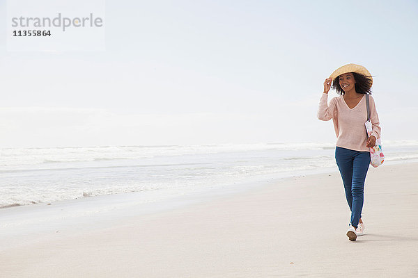 Junge Frau geht am Strand spazieren