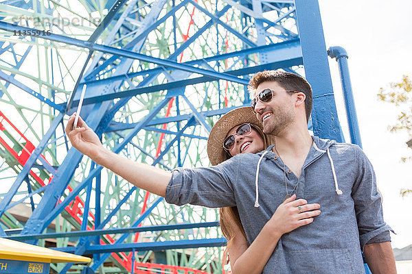 Pärchen auf dem Rummelplatz mit Smartphone zum Selbstfahren  Coney Island  Brooklyn  New York  USA