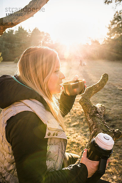 Frau entspannt sich und trinkt Kaffee auf einer Baumkrone  Augsburg  Bayern  Deutschland