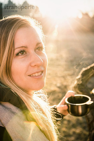 Frau trinkt Kaffee an einem sonnigen Tag