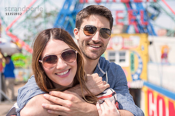 Paar mit Sonnenbrille schaut lächelnd in die Kamera  Coney Island  Brooklyn  New York  USA