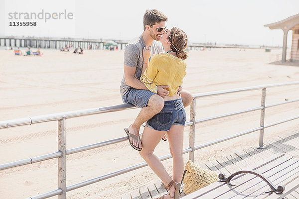 Paar auf dem Geländer beim Strandkuss  Coney Island  Brooklyn  New York  USA