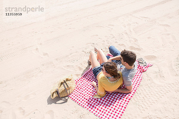 Paar liegt auf einer Picknickdecke am Strand  Coney Island  Brooklyn  New York  USA