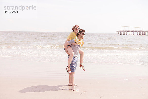 Mann am Strand gibt Frau Huckepack  Coney Island  Brooklyn  New York  USA