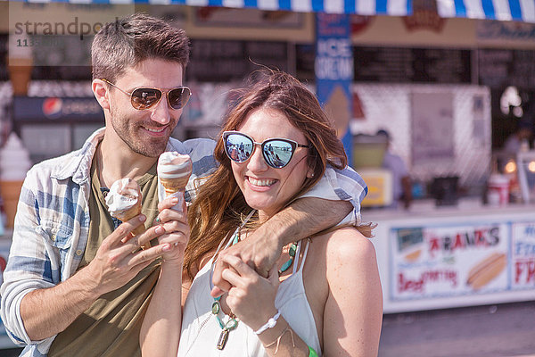 Ein Paar auf der Promenade hält lächelnd Eiswaffeln in der Hand  Coney Island  Brooklyn  New York  USA