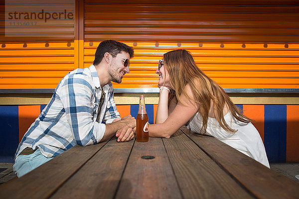 Paar sitzt von Angesicht zu Angesicht am Picknicktisch  Coney Island  Brooklyn  New York  USA