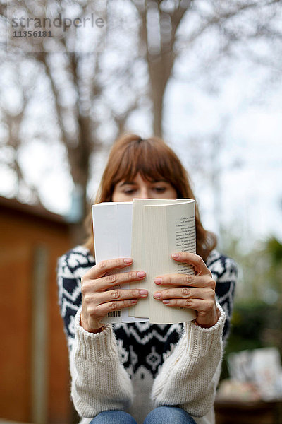 Frau liest Buch  Gesicht verdunkelt