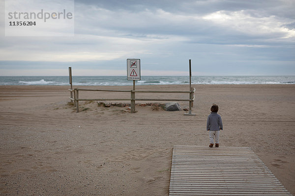 Mädchen am Strand mit Blick auf den Ozean