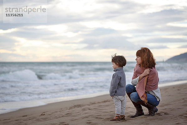 Mutter und Tochter am Strand mit Blick auf den Ozean