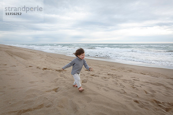 Mädchen rennt am Strand am Meer