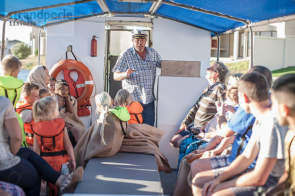 Kapitän im Gespräch mit Touristen auf Bootsfahrt  Kapstadt  Südafrika