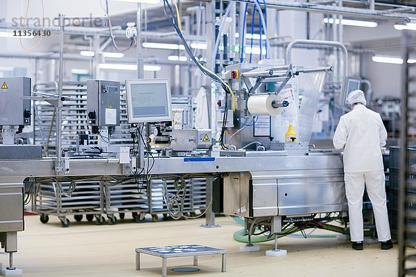 Fabrikarbeiter  der Maschinen zur Nahrungsmittelproduktion bedient