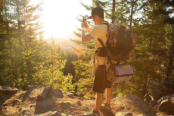 Männlicher Wanderer  der ein Smartphone-Foto vom Waldrücken aus macht  Mount Hood National Forest  Oregon  USA