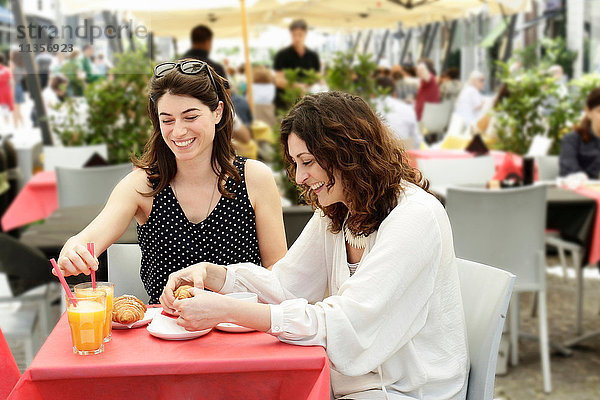 Zwei Frauen beim Plaudern und Frühstücken im Straßencafé  Mailand  Italien