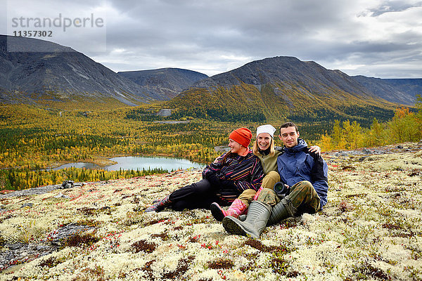 Porträt von drei jungen erwachsenen Wanderern  die zusammensitzen  Khibiny-Gebirge  Kola-Halbinsel  Russland