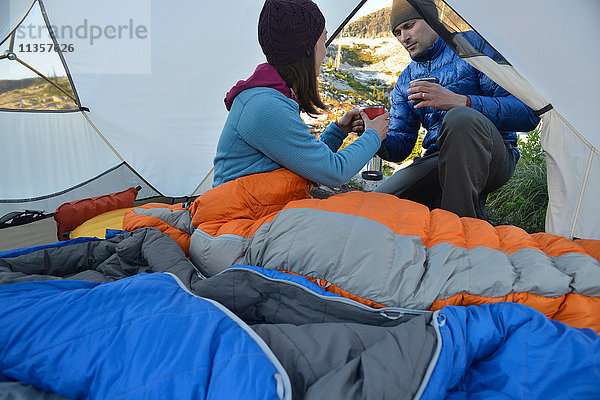 Mann gibt seiner Freundin Kaffee im Zelt am Fault Lake  Selkirk Mountains  Idaho