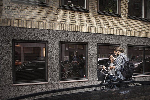 Freunde mit Fahrrädern  die sich im Fenster der Stadt spiegeln