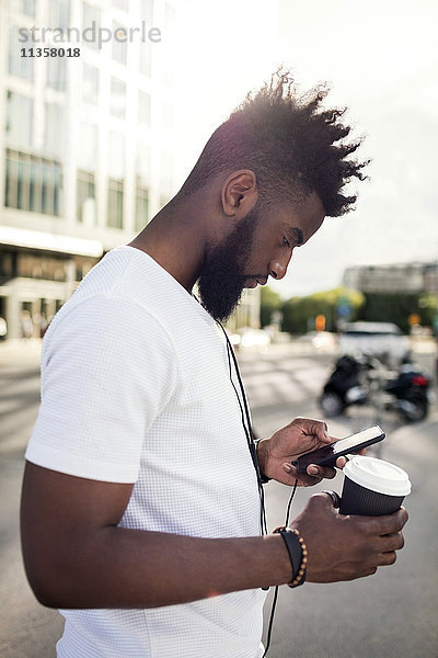 Junger Mann im Profil mit Smartphone