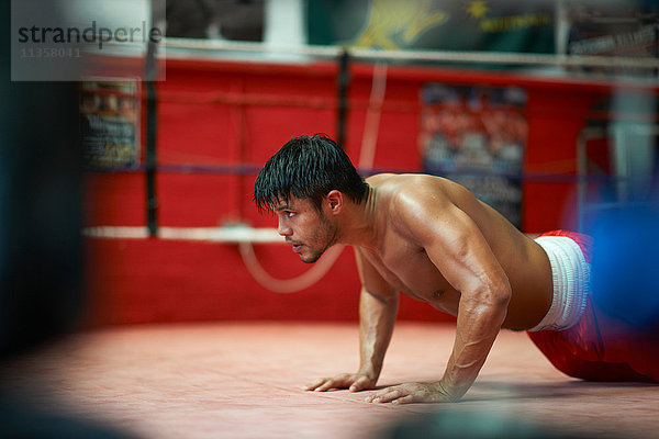 Boxer macht Liegestütze im Boxring