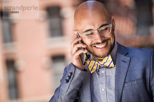 Geschäftsmann im Freien  benutzt Smartphone  lächelt