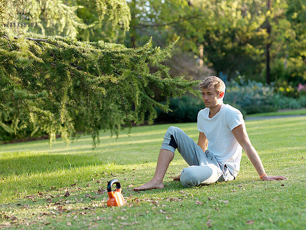 Junger Mann entspannt sich im Gras  macht eine Pause vom Sport