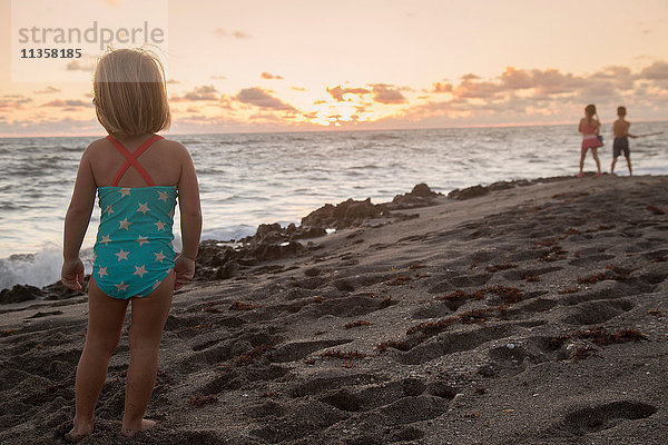 Mädchen schaut bei Sonnenaufgang aufs Meer hinaus  Blowing Rocks Preserve  Jupiter Island  Florida  USA