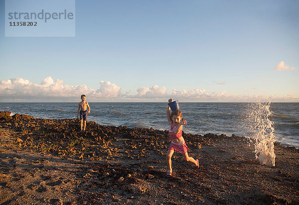 Mädchen rennt vor der plätschernden Welle am Strand weg  Blowing Rocks Preserve  Jupiter Island  Florida  USA