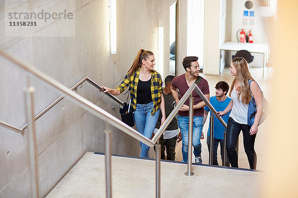 Gruppe von Studenten  die an der Hochschule eine Treppe hinaufgehen