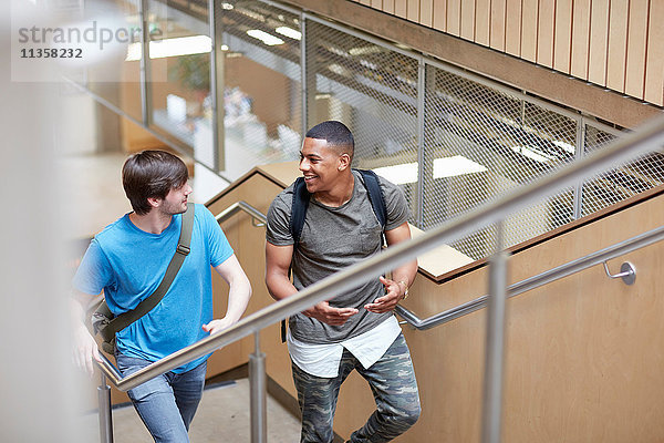 Zwei männliche Studenten steigen an der Hochschule die Treppe hinauf