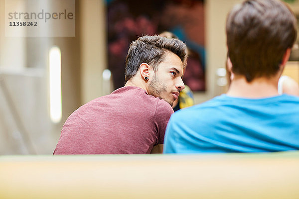 Rückansicht der männlichen Studenten in der Kantine der Hochschule