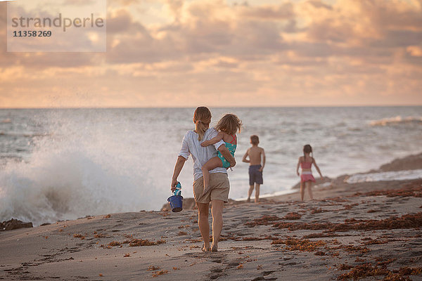 Mutter mit Tochter bei Sonnenaufgang am Strand  Blowing Rocks Preserve  Jupiter Island  Florida  USA